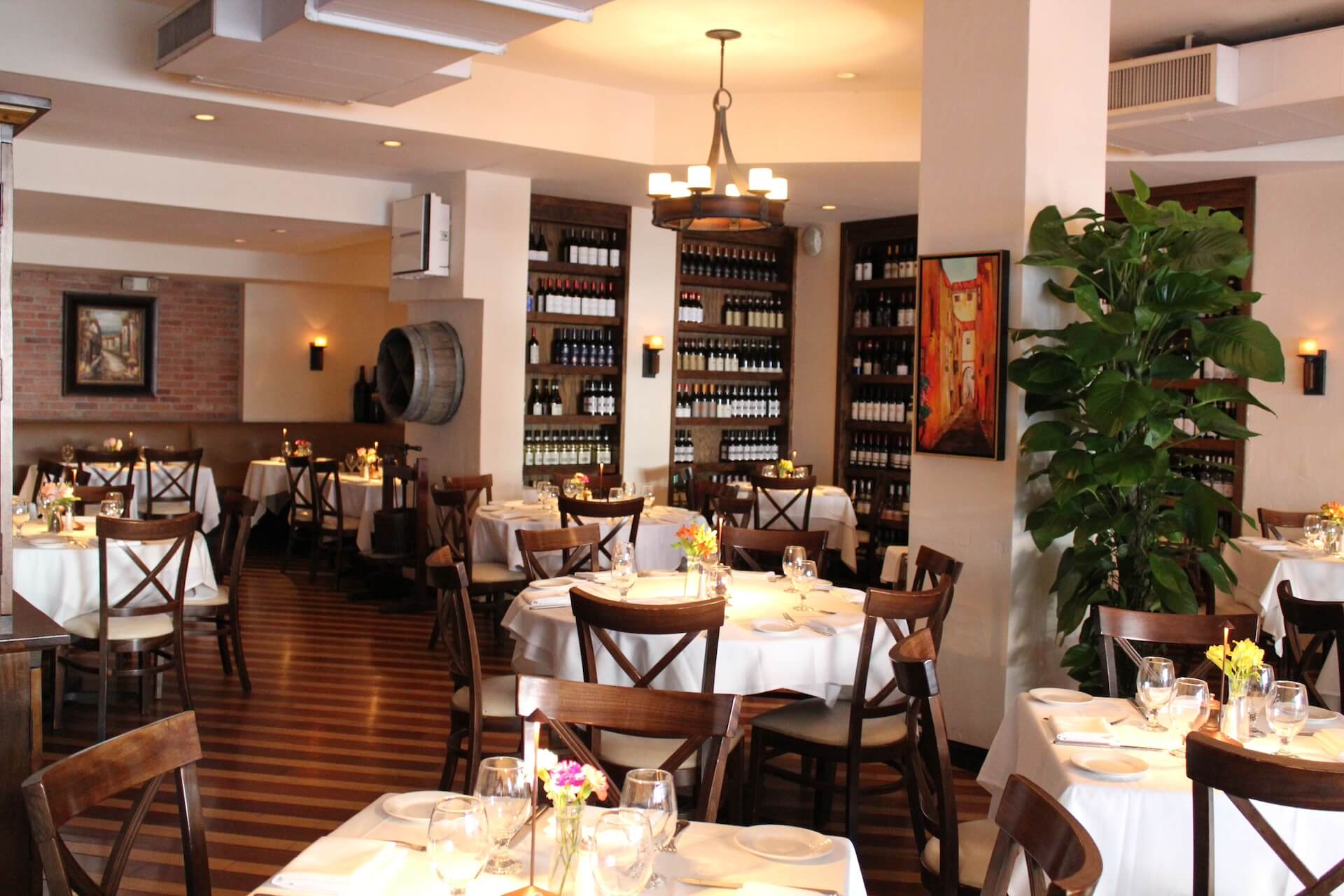 The dining room with wine shelves and round tables set with white linens