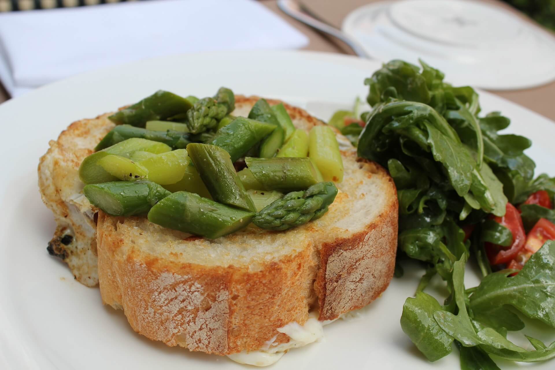 Asparagus on toasted bread with an arugula and tomato salad